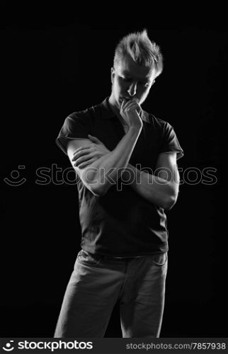 Expressive handsome young man - studio shot, black and white image, black background