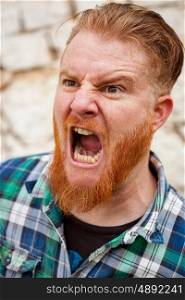Expressive red haired hipster man with blue plaid shirt expressing a emotion