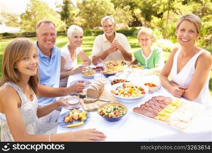 Extended Family Enjoying Meal In Garden