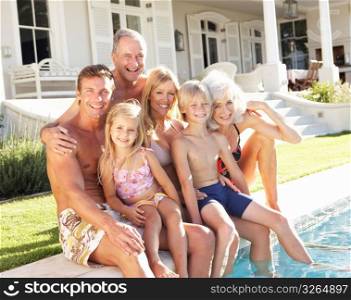 Extended Family Outside Relaxing By Swimming Pool