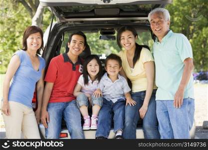 Extended family sitting in tailgate of car