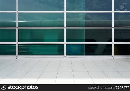 Exterior of a modern glass wall facade building with clean marble floor .