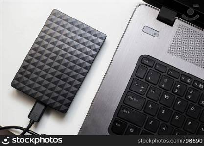 External hard drive connect to laptop computer, transfer or backup data between laptop and hard disk close-up. External hard drive connect to laptop computer, transfer or backup data between laptop and hard disk