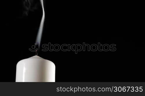 Extinguished candle with beautiful dancing smoke and copy space for something.