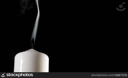 Extinguished candle with beautiful dancing smoke and copy space for something.