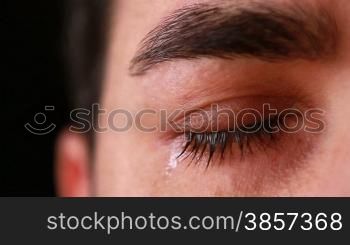 Extreme close-up of an young man eye crying