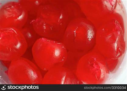 Extreme close-up of glace cherries in a pot.