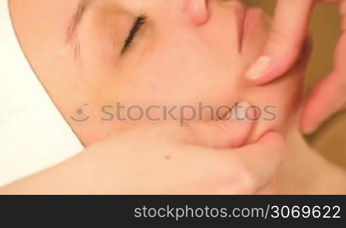 Extreme close-up shot of therapists hands doing a facial massage at beauty treatment salon