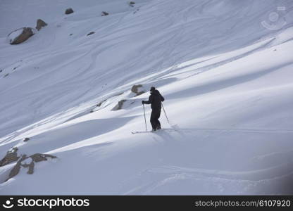 extreme freeride skier skiing on fresh powder snow in downhill at winter mountains