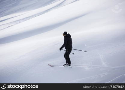 extreme freeride skier skiing on fresh powder snow in downhill at winter mountains