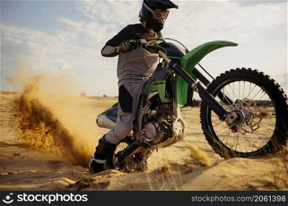 Extreme motocross rider riding on dirt track over sand. Speed offroad racing challenge. Extreme motocross rider riding on dirt track