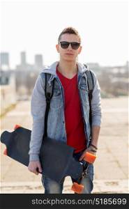 extreme sport and people concept - happy young man or teenage boy with backpack and on longboard in city. happy young man or teenage boy with longboard