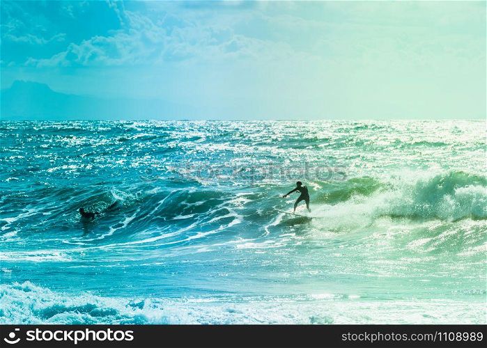 Extreme surfers riding some waves on the sea in France