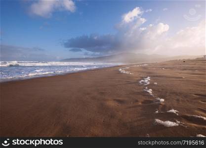 Extreme wide-angle scenic view of sandy beach in Florida. Blue sky, ocean waves, summer morning