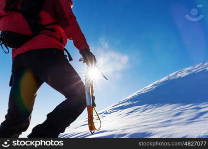 Extreme winter sports: climber at the top of a snowy peak in the Alps. Concepts: determination, success, brave.