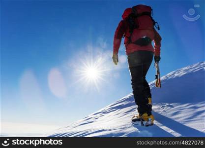 Extreme winter sports: climber at the top of a snowy peak in the Alps. Concepts: determination, success, brave.
