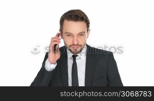 Exuberant businessman celebrating a victory or success punching the air with his fists and smiling happily while holding his mobile phone, isolated on white