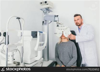 Eye doctor checking patient&rsquo;s eyes on a machine. Optometry, medical diagnosis.. Eye doctor checking patient&rsquo;s eyes on a machine.
