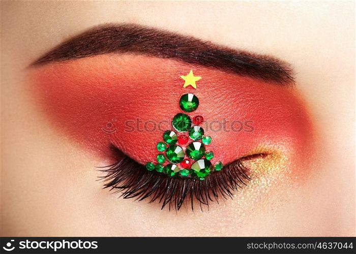 Eye girl makeover christmas tree. Winter christmas makeup. Beauty fashion. Eyelashes. Cosmetic Eyeshadow. Makeup detail. Creative woman holiday make-up