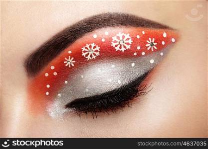 Eye girl makeover snowflakes. Winter christmas makeup. Beauty fashion. Eyelashes. Cosmetic Eyeshadow. Makeup detail. Creative woman holiday make-up
