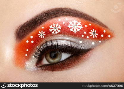 Eye girl makeover snowflakes. Winter christmas makeup. Beauty fashion. Eyelashes. Cosmetic Eyeshadow. Makeup detail. Creative woman holiday make-up