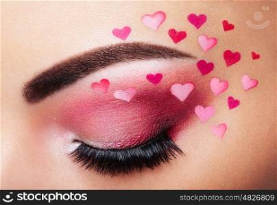 Eye make-up girl with a heart. Valentine's day makeup. Beauty fashion. Eyelashes. Cosmetic Eyeshadow. Makeup detail. Creative woman holiday make-up