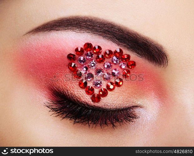 Eye make-up girl with a heart. Valentine's day makeup. Beauty fashion. Eyelashes. Cosmetic Eyeshadow. Makeup detail. Creative woman holiday make-up