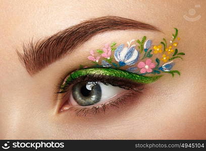 Eye makeup girl with a flowers. Spring makeup. Beauty fashion. Eyelashes. Cosmetic Eyeshadow. Make-up detail. Creative woman holiday make-up