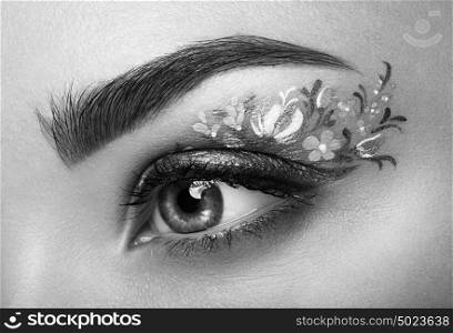 Eye makeup girl with a flowers. Spring makeup. Beauty fashion. Eyelashes. Cosmetic Eyeshadow. Make-up detail. Creative woman holiday make-up. Black and White photo
