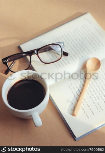 eyeglasses and book with black coffee , retro filter effect