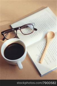 eyeglasses and book with black coffee , retro filter effect