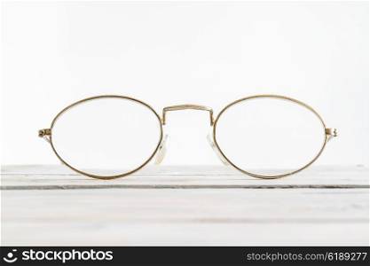 Eyeglasses on a wooden desk in bright environment