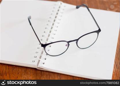 Eyeglasses on opened spiral notebook , stock photo
