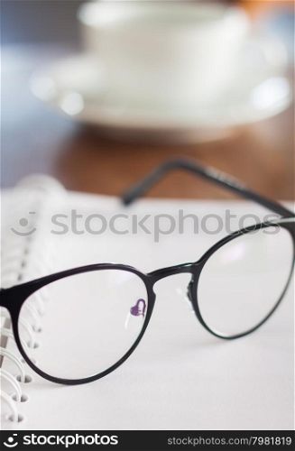 Eyeglasses on opened spiral notebook , stock photo