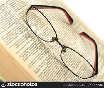 Eyeglasses on the old thick book. A photo close up