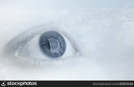 Eyes health. Female blue eye on cloudy sky background