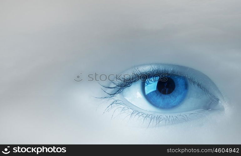 Eyes health. Female blue eye on cloudy sky background