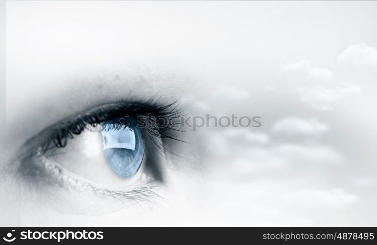 Eyes health. Female blue eye on cloudy sky background