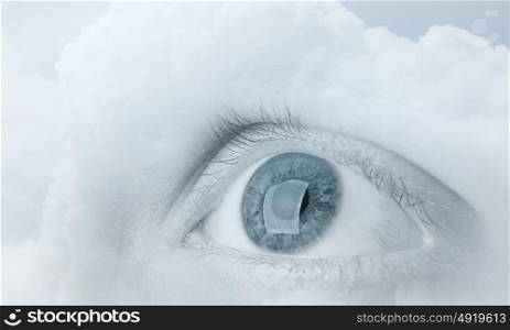 Eyes health. Female blue eye on cloudy sky background