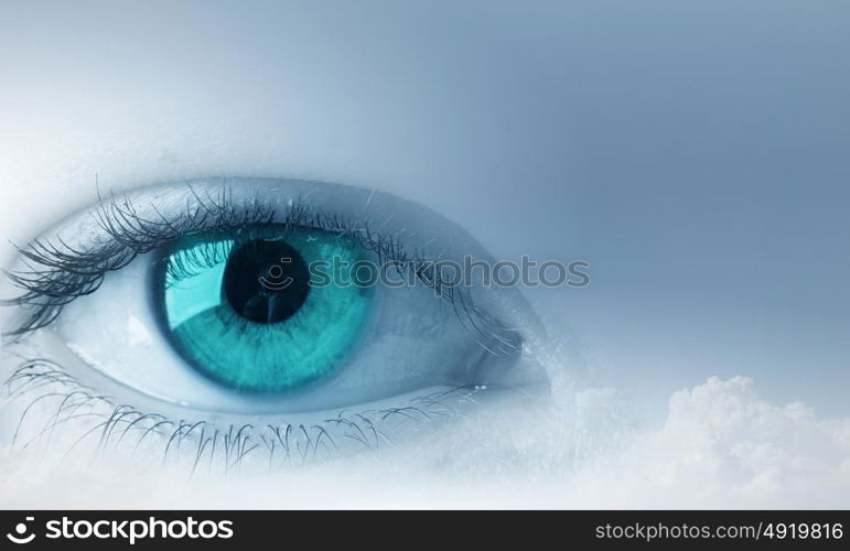 Eyes health. Female blue eye on cloudy sky background