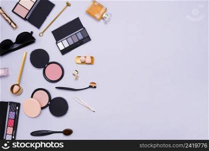eyeshadows palette oval brushes compact powder sponge perfume bottle clutcher sunglasses purple background