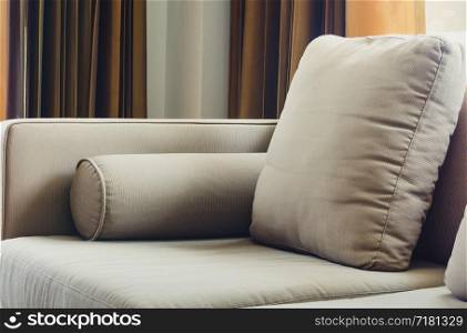 Fabric sofa with cushions in living room and natural soft window light