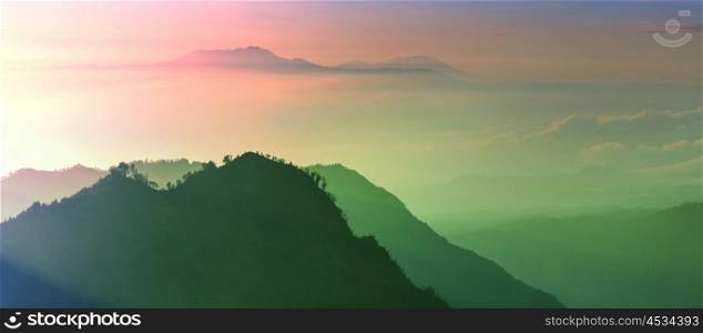 Fabulous light of sun rays at beautiful sunrise in mountains of Java island, Indonesia