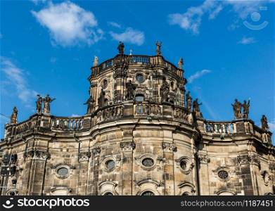Facade of an ancient European castle with statues, blue sky on background. Summer tourism and travels, ancient architecture and buildings, famous europe landmark