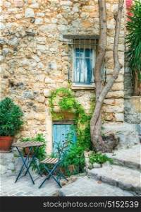 Facade of an old stone house with flowers in the village Tourrettes-sur-Loup , France.