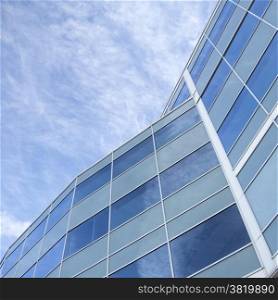 facade of glass and steel with reflections of blue sky and clouds