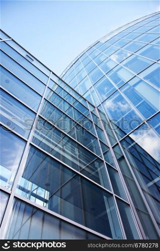 facade of modern glass blue office and sky reflected