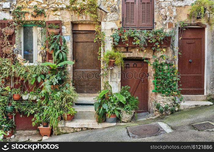 Facade of old French house with flower pots