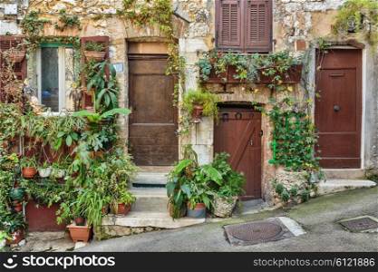 Facade of old French house with flower pots