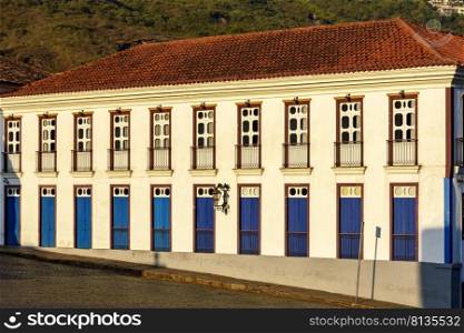 Facade of old house in colonial architecture in the city of Ouro Preto, Minas Gerais with blue, brow and yellow windows and doors. Facade of old house in colonial architecture with blue, brow and yellow windows and doors